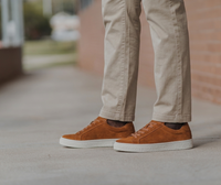 Mens tan suede low top sneakers worn with stone chinos. A simple smart casual outfit for everyday wear.