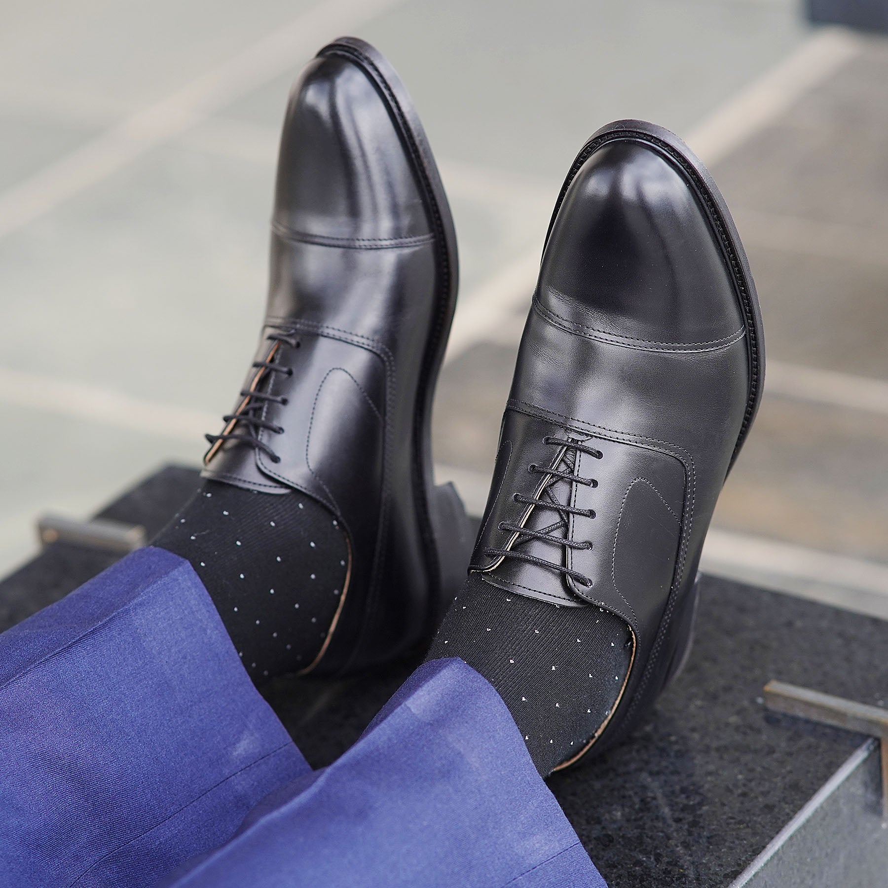 Black oxford shoes paired with slim fit navy-blue dress pant with double stitching on the toe cap