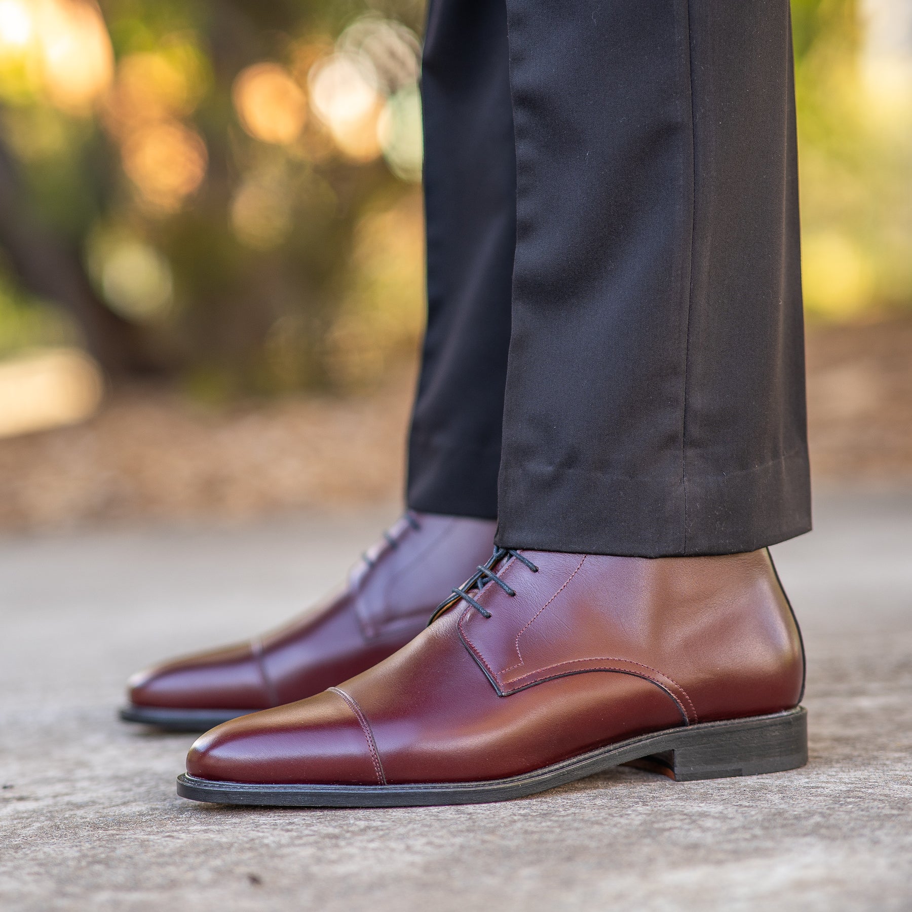 Mens burgundy leather boots paired with slim fit suit and tailored shirt.