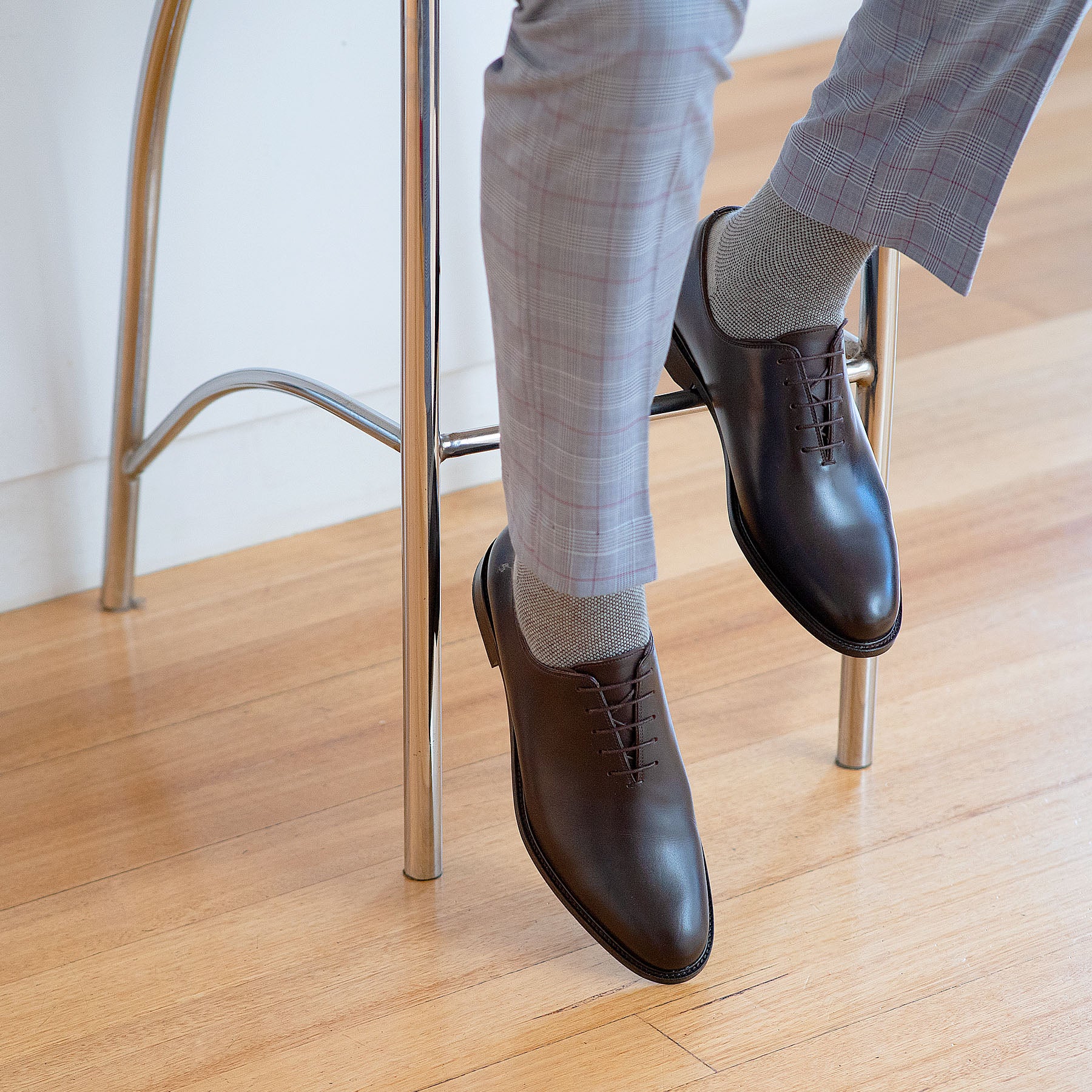 Brown oxford shoes paired with tailored suits and stripped socks.