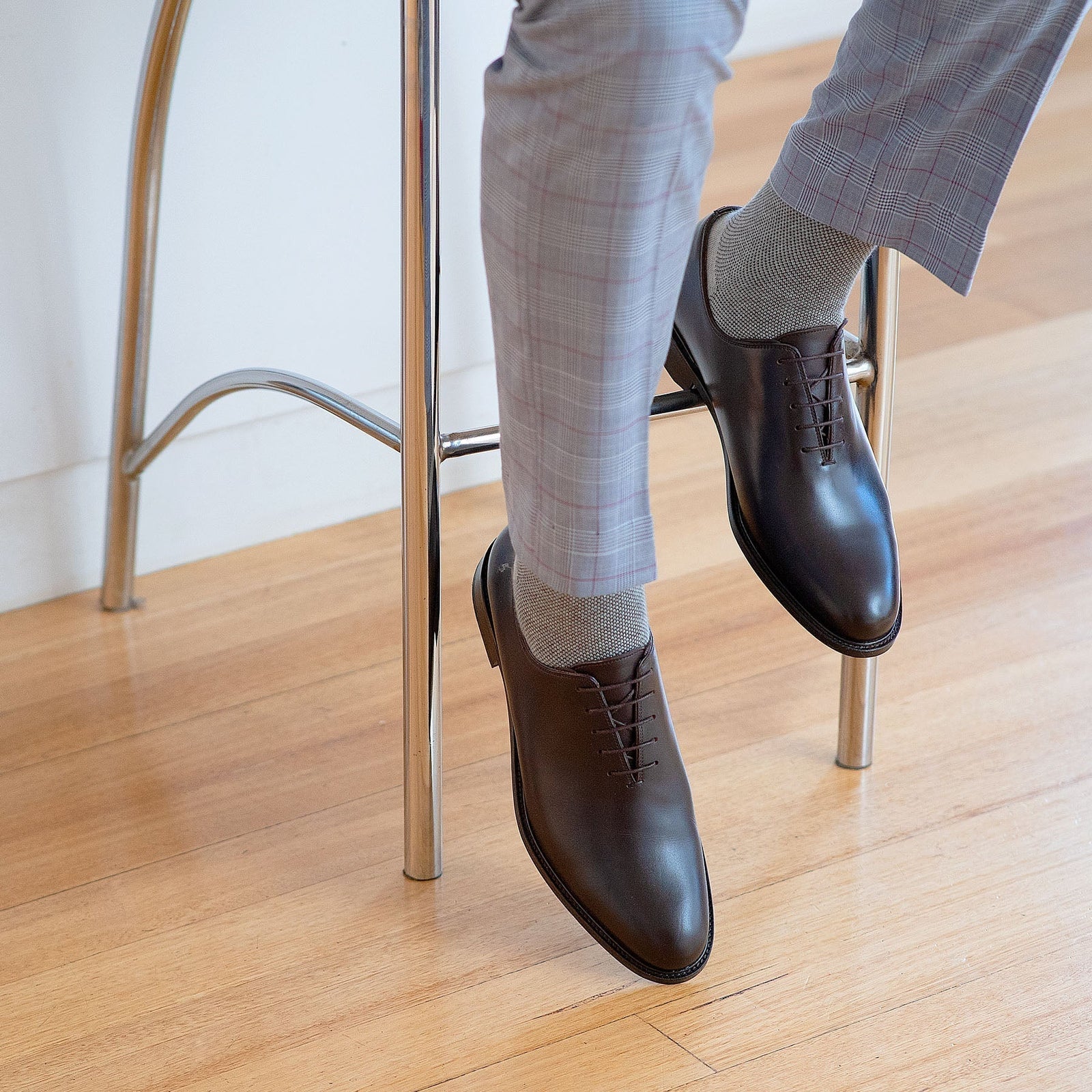 Brown leather oxford shoes paired with tailored suits and stripped socks.