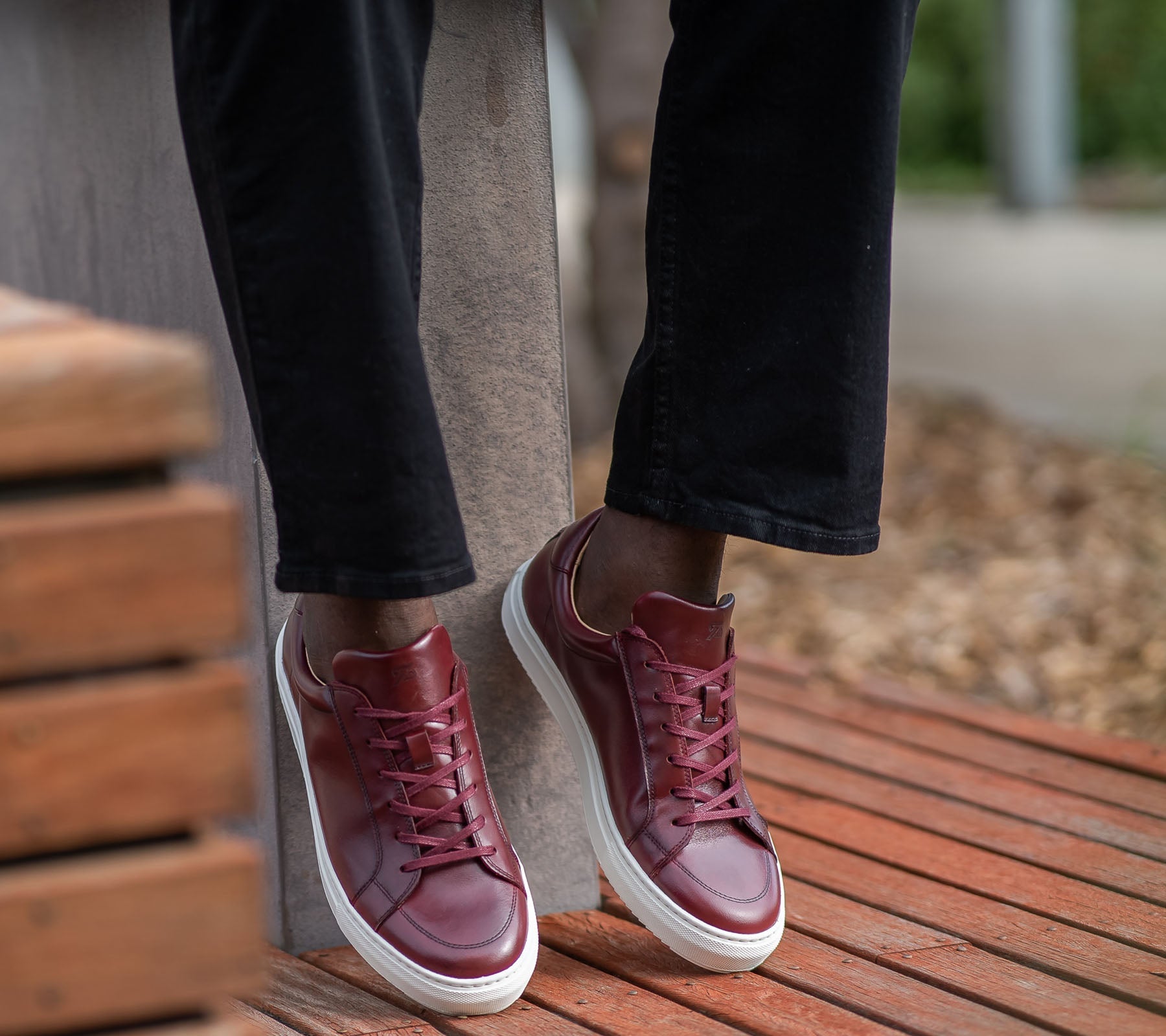 Mens burgundy sneakers paired with jeans for casual look