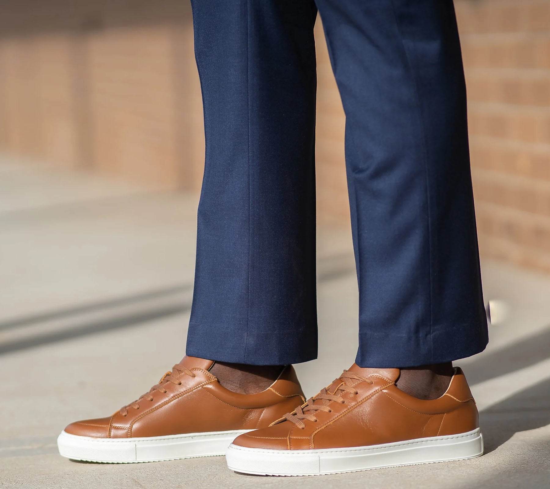 Black leather sneakers paired with khaki trousers and polo shirts.