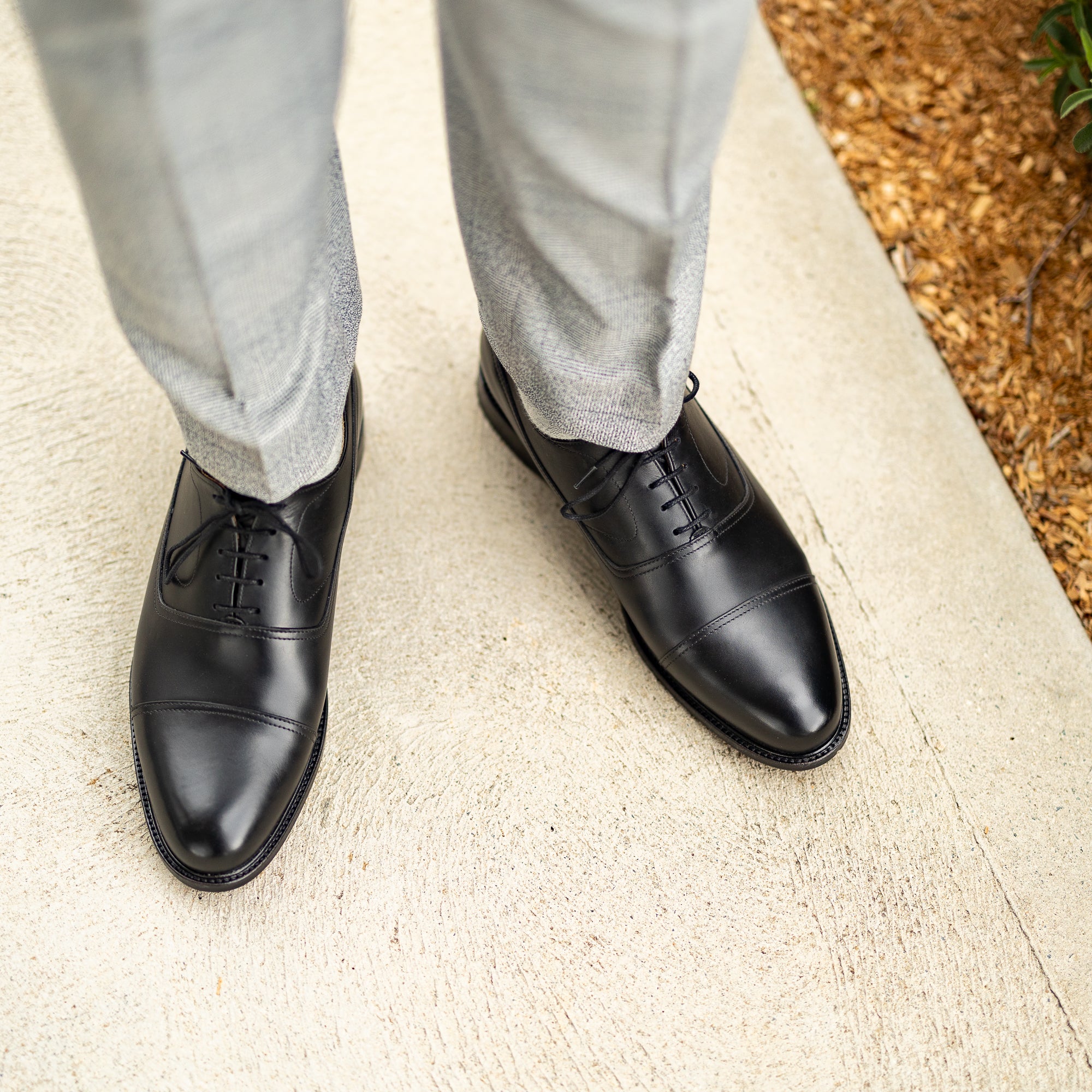 Mens black dress shoes with cap toe paired nicely with business suits 