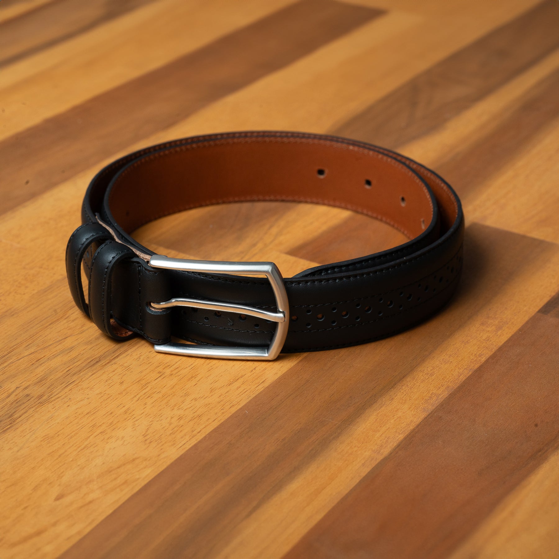 Buy smart black belt for men. Brogue details give a classic touch to suits, jeans, and smart casual