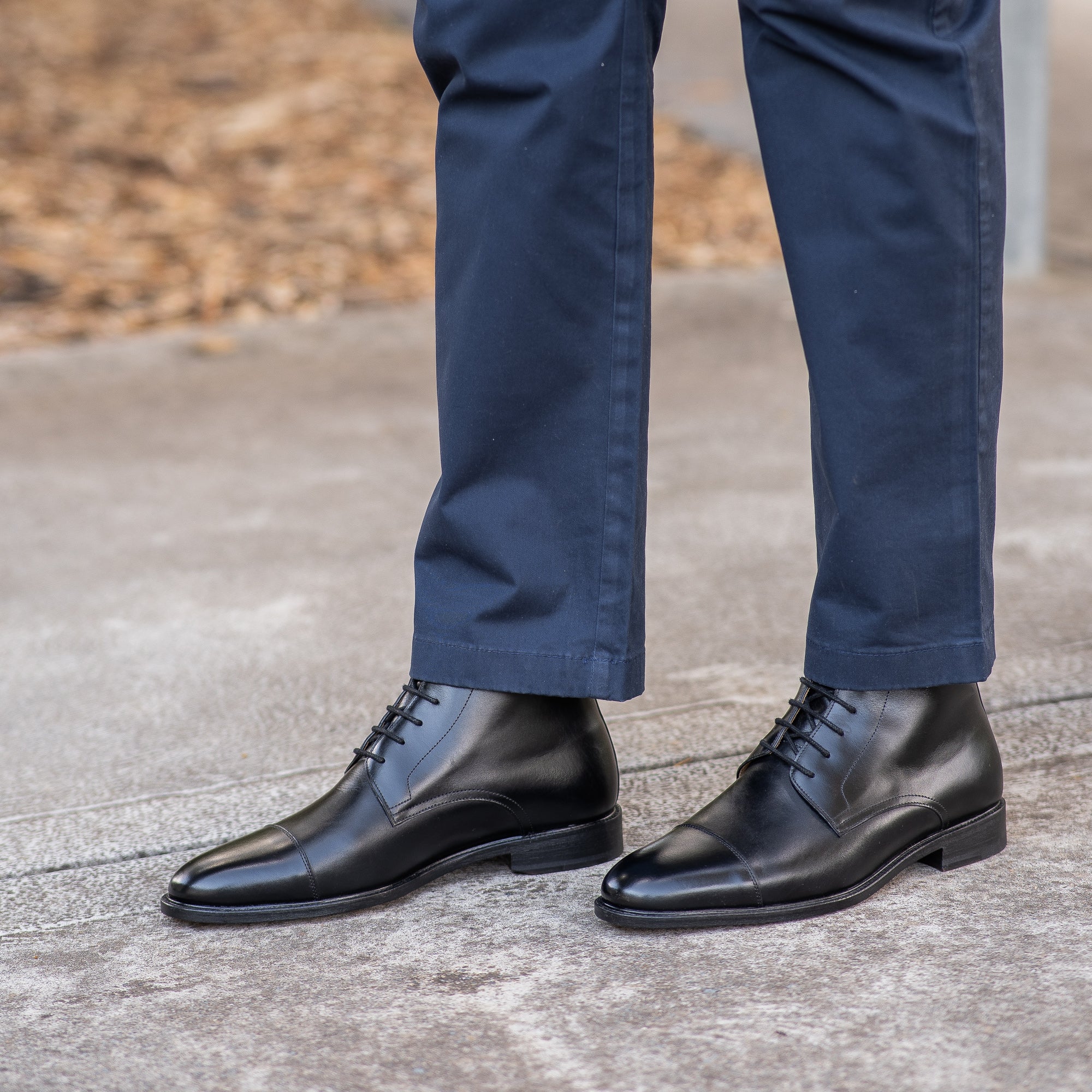 The Sahara black boots for men, paired with khaki pants and Rolex watch.