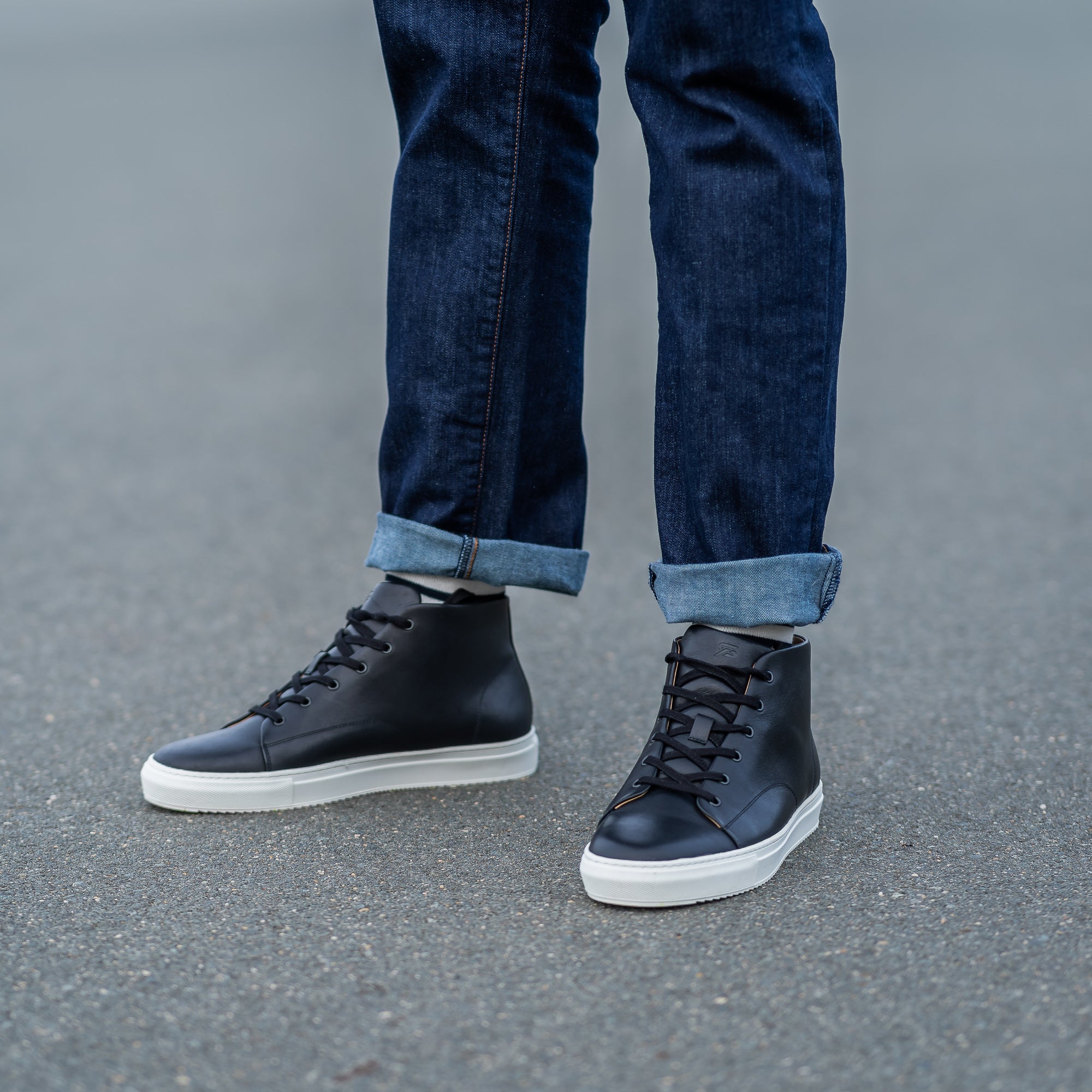 The Explorer high top sneakers in black leather, matched with khaki and denim shirt