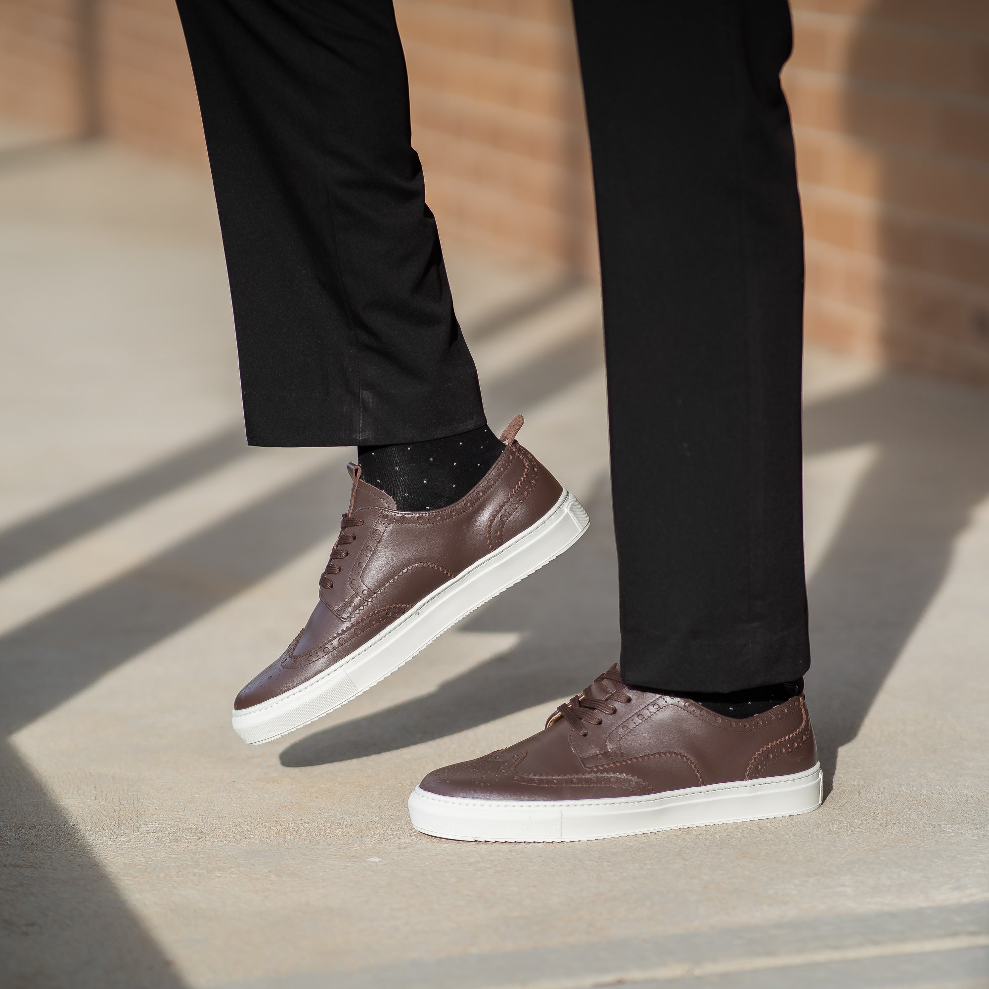 The Alpha low top brogue trainers for men with high quality leather paired with dress trousers and business shirt