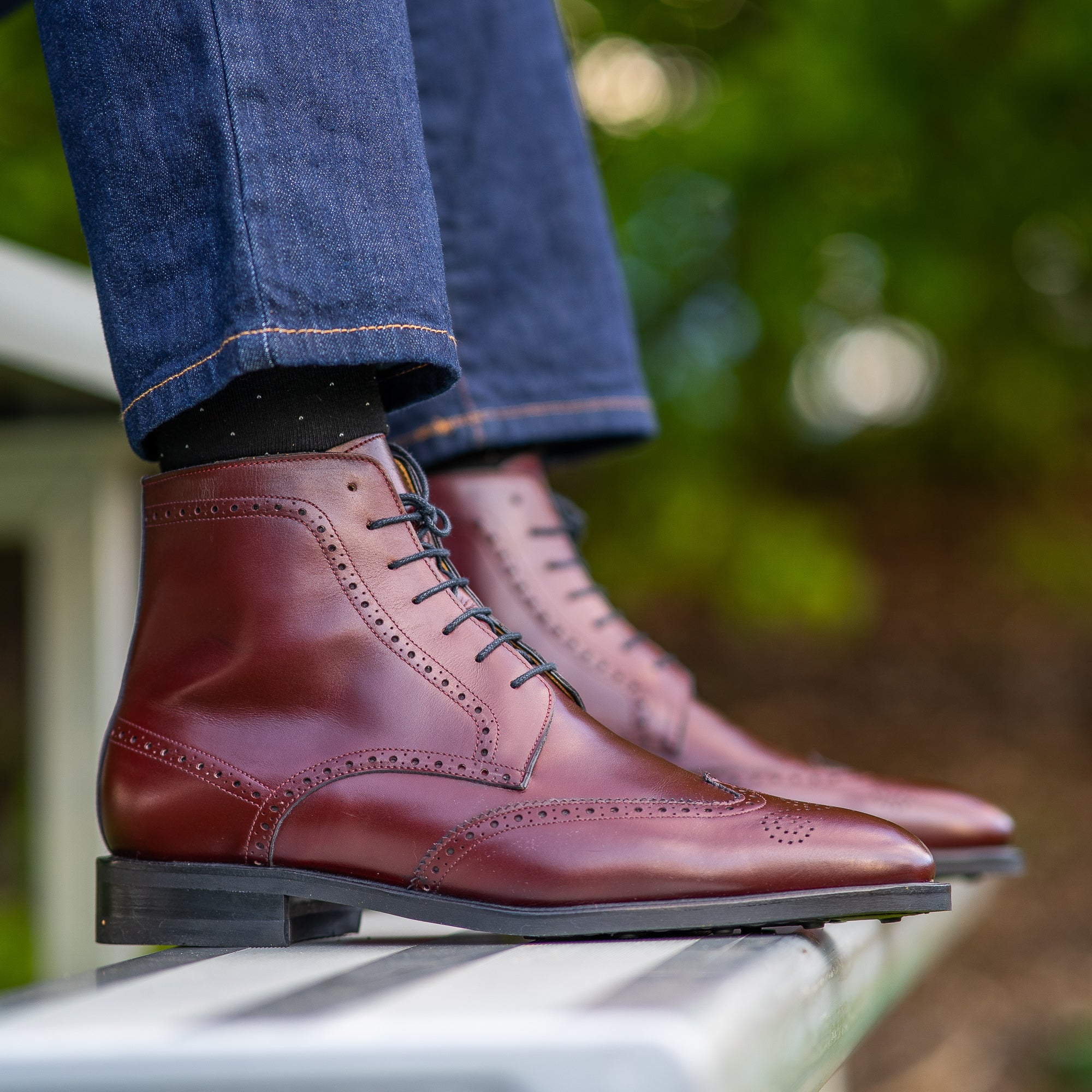 The Outback wingtip lace up calf leather boot in burgundy, paired with blue jeans and printed 100% cotton shirt