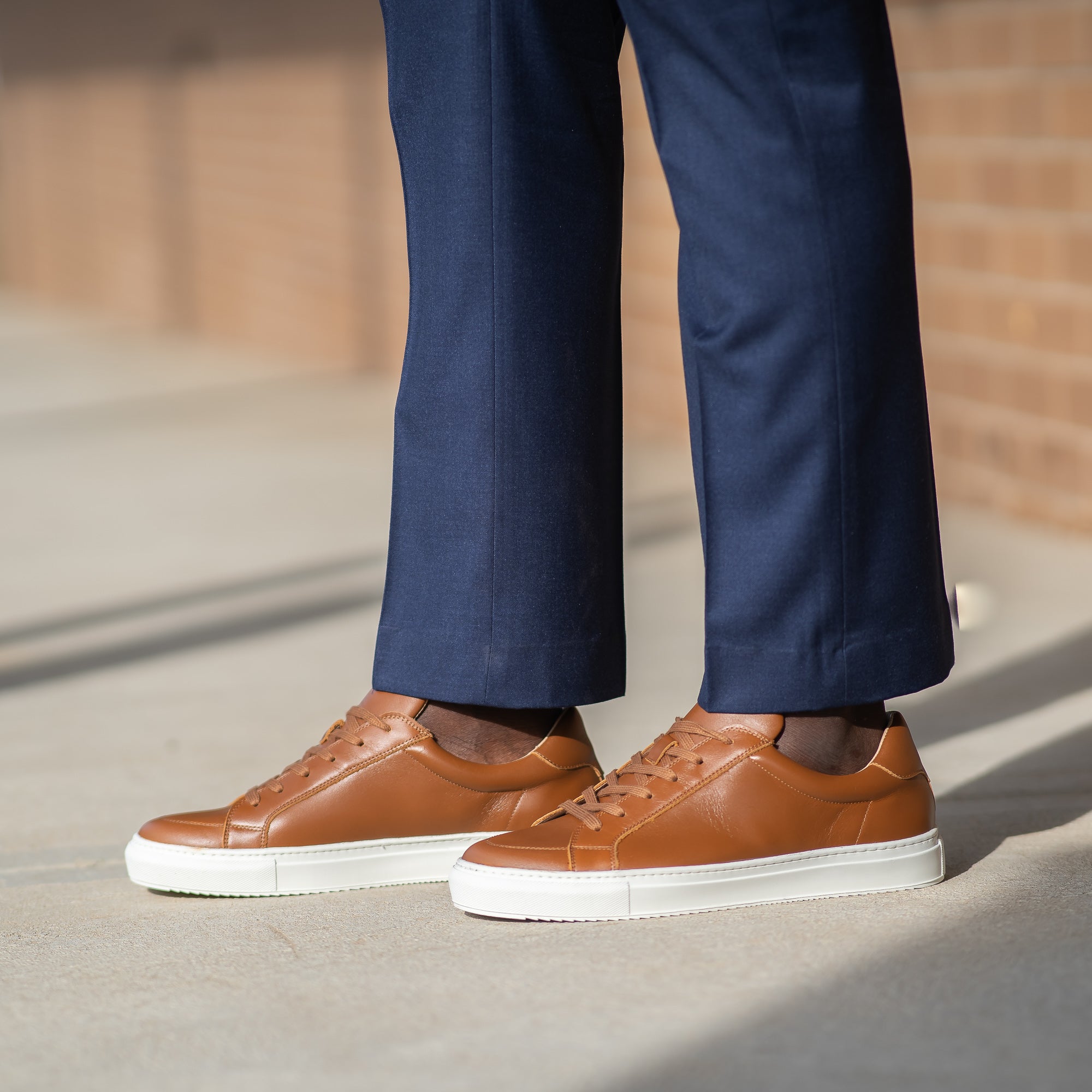 Slim fit dress pants and business shirt paired with the Vin low top sneakers in tan leather for trendy look