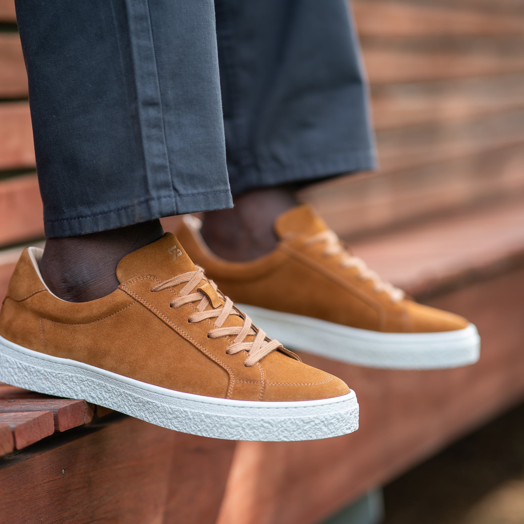 The Vin low top sneakers for men in cognac suede, worn with slim fit taper jeans with white plain polo shirt.