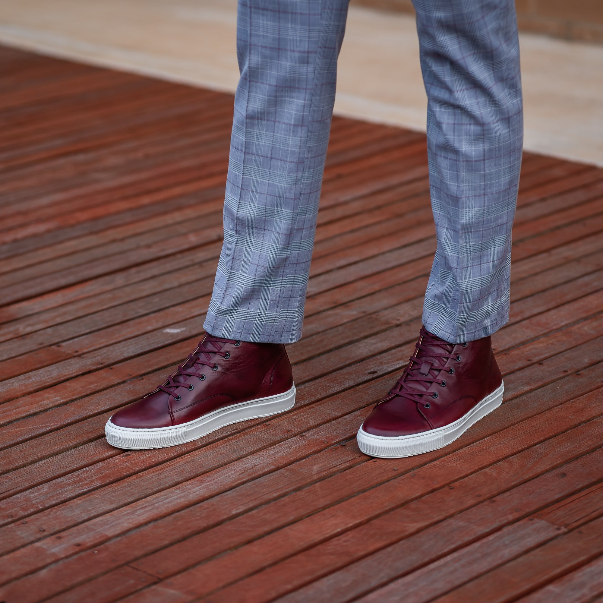 The Explorer high top leather sneakers in burgundy, paired with dress pants and tailored men suit.