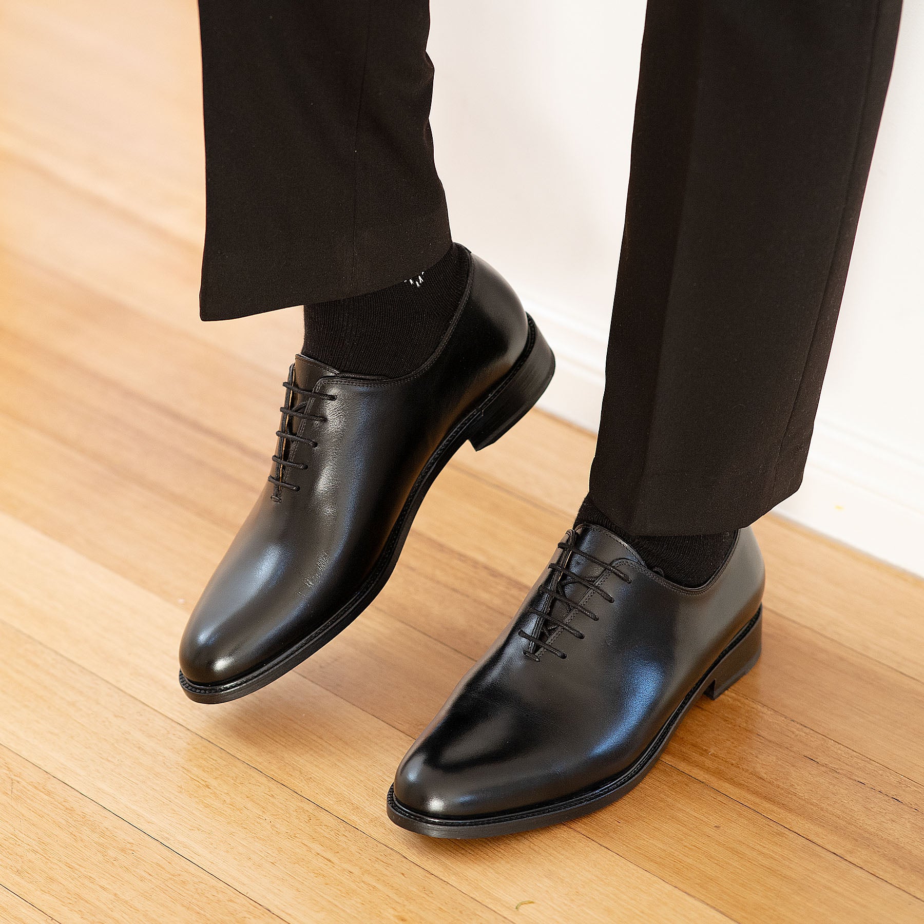 A pair of Kingston oxford wholecut in black paired with bespoke tailored double-breasted suit