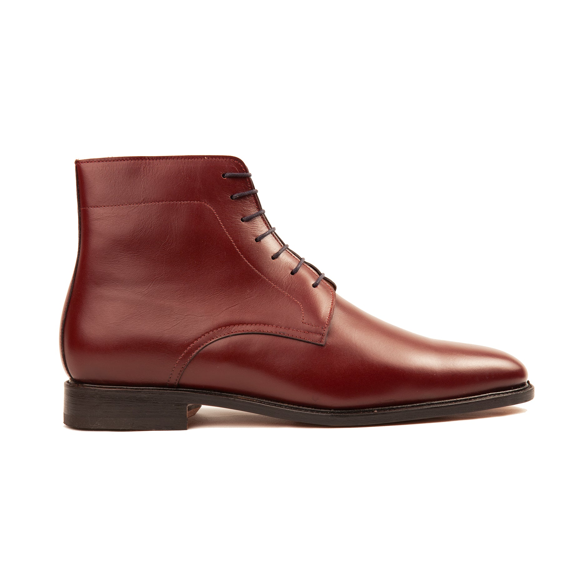 The Kingsman men’s plain toe leather boot in burgundy featuring full grain calf leather, blind lace eyelets and storm welt