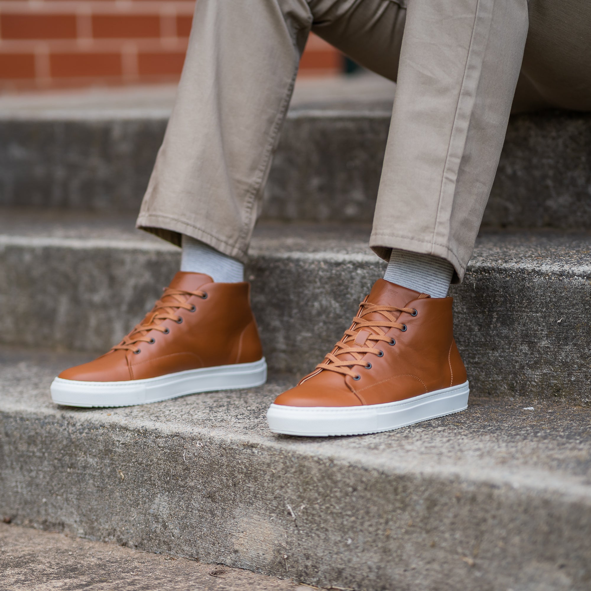 The Explorer high top leather sneakers for men in tan, worn with casual blazer and beige chinos