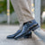 Men's wingtip boot with decorated brogues paired with beige cotton Khaki and designer jacket