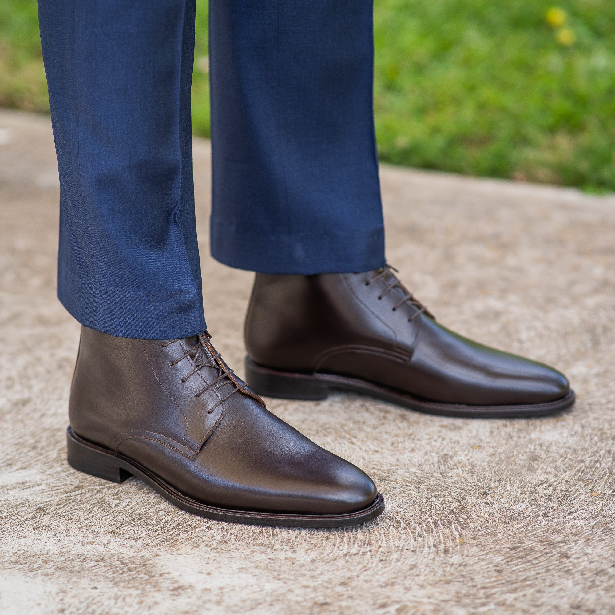 Brown dress boots for men featuring storm leather welt paired with bespoke tailored suit