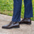 Men brown leather boots made using blake welted stitched construction paired with smart corporate outfit