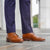 Mens tan boots styled with striped blue pants and shirt.