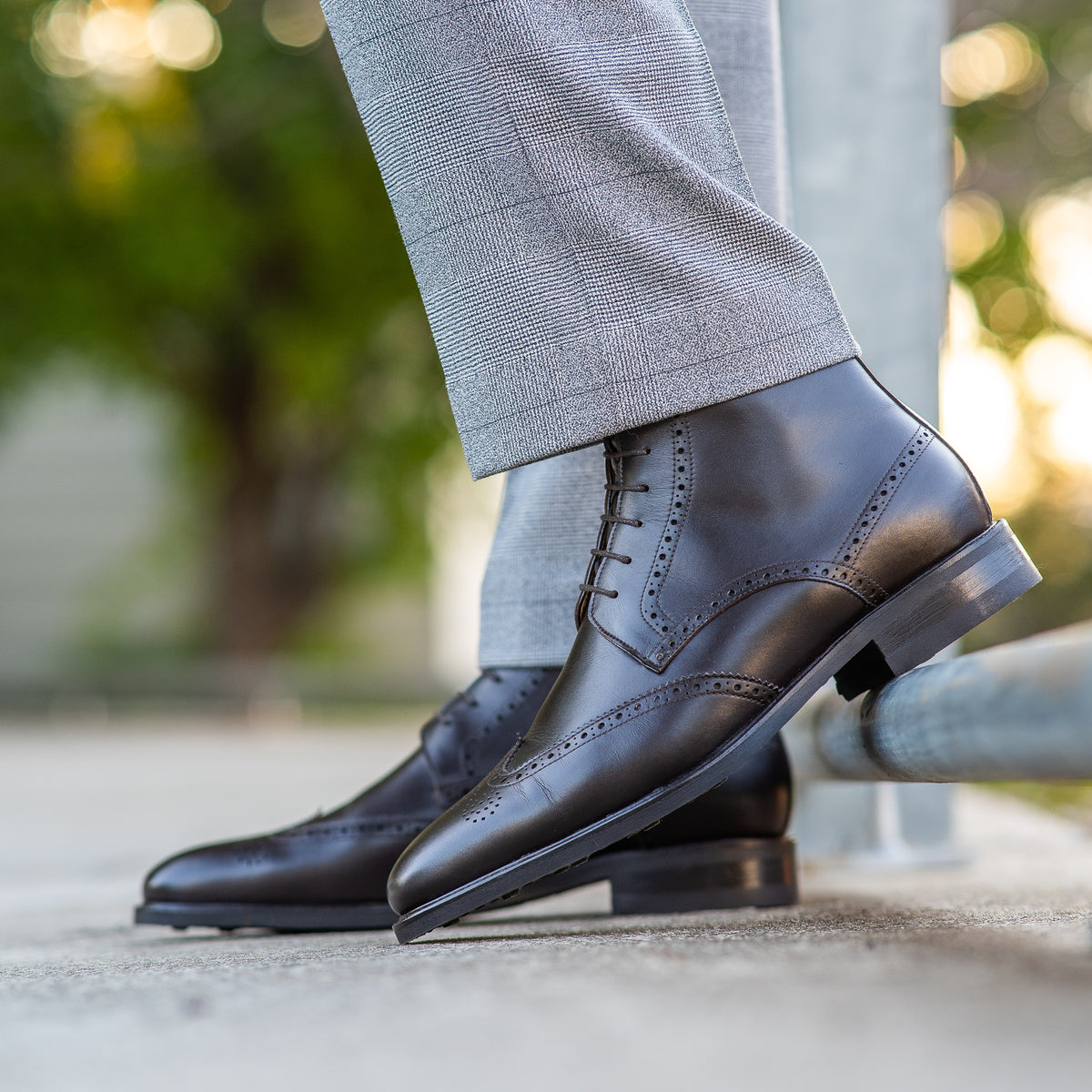 Mens brown wingtip brogue boots featuring wingtip design and paired with suit for professional look