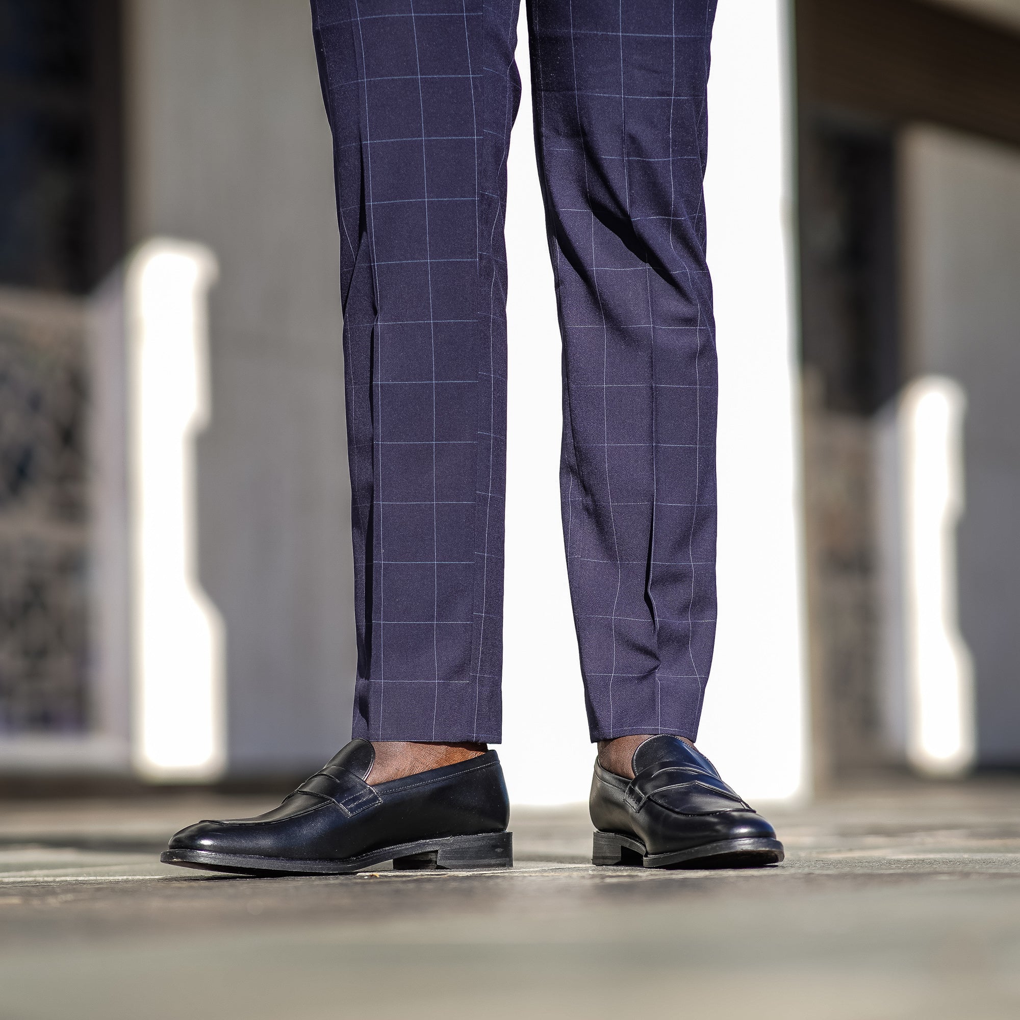 Mens black penny loafers paired with bespoke dress pant.