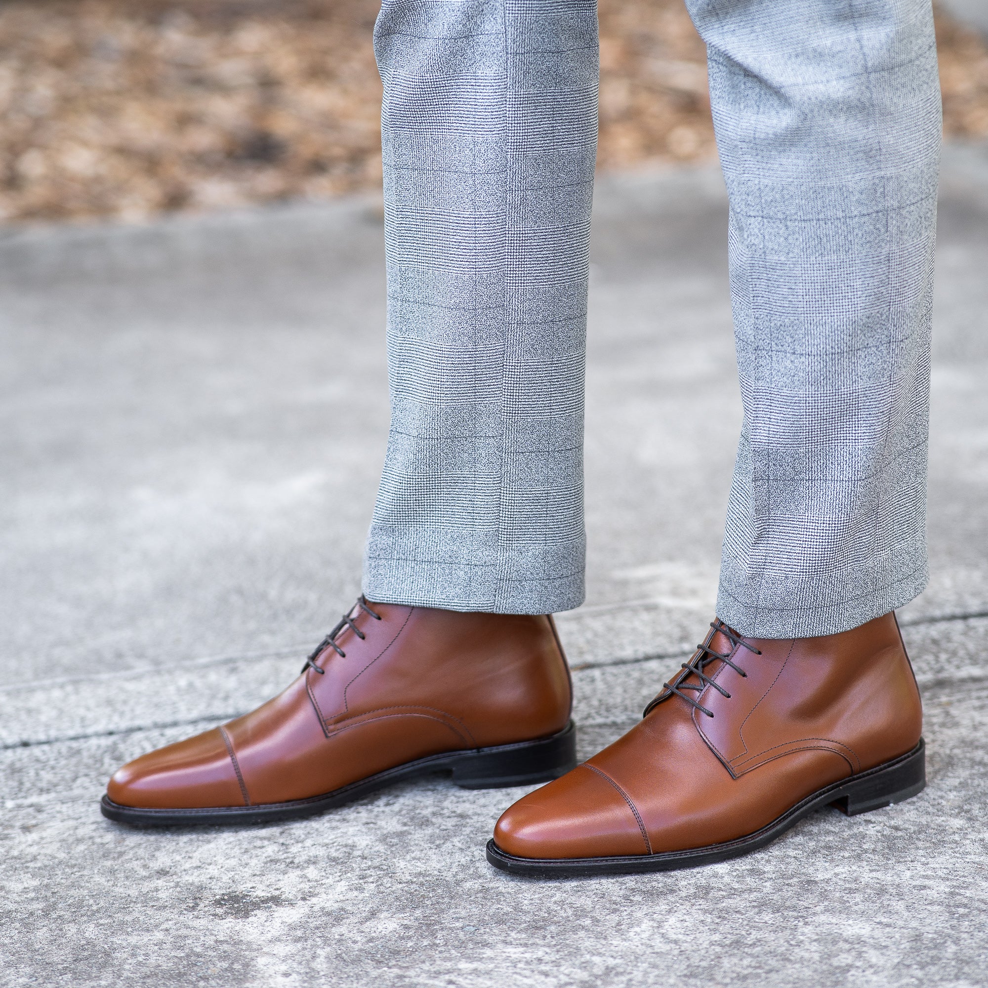 Mens tan boots with double stitching at the toe cap and paired with tailored suit