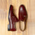 Burgundy double monk strap shoes crafted using blake rapid stitched construction for durability