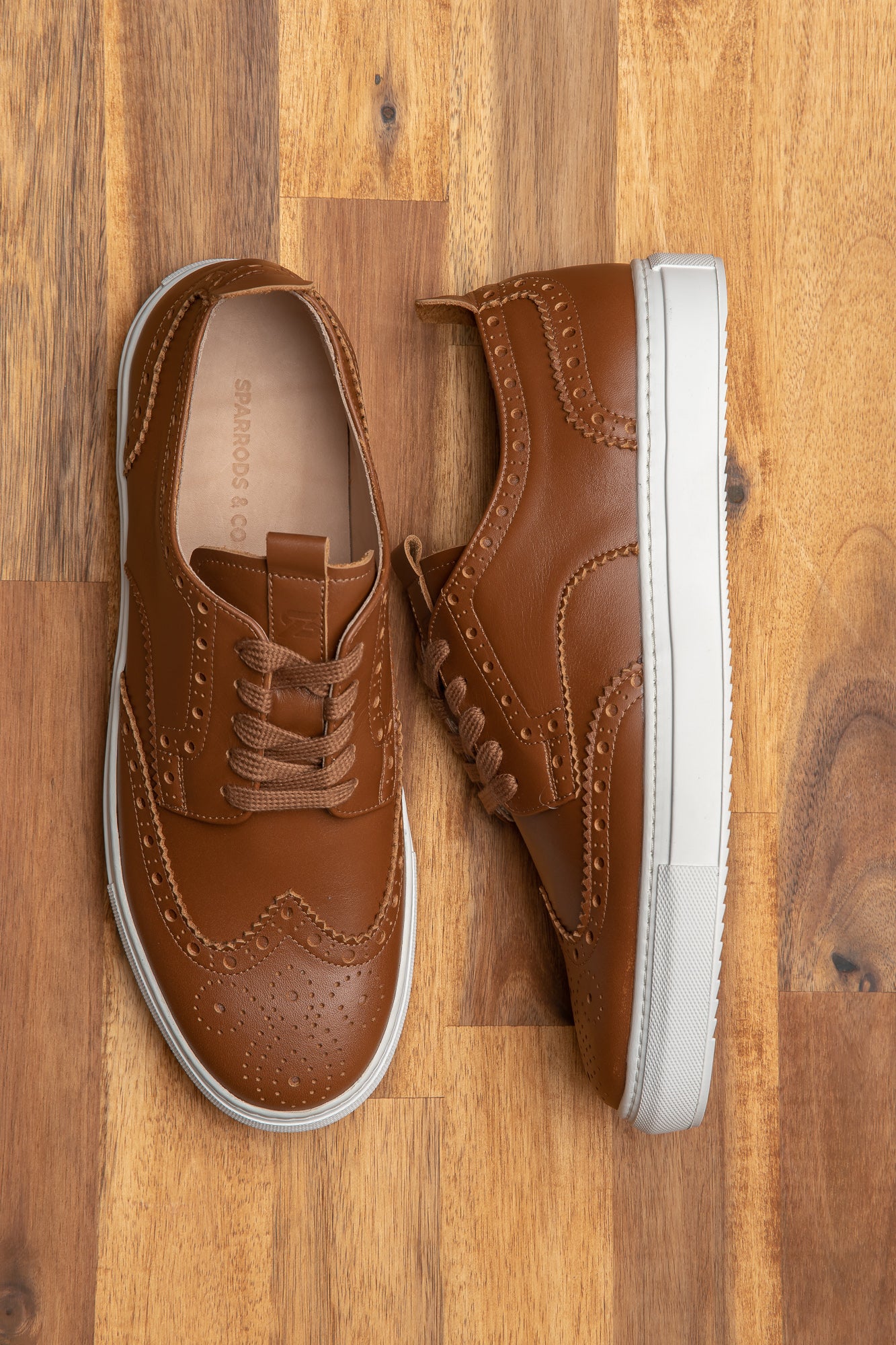 The low top wingtip sneakers, the Alpha in cognac, beautiful perforation, and medallion on the toe cap