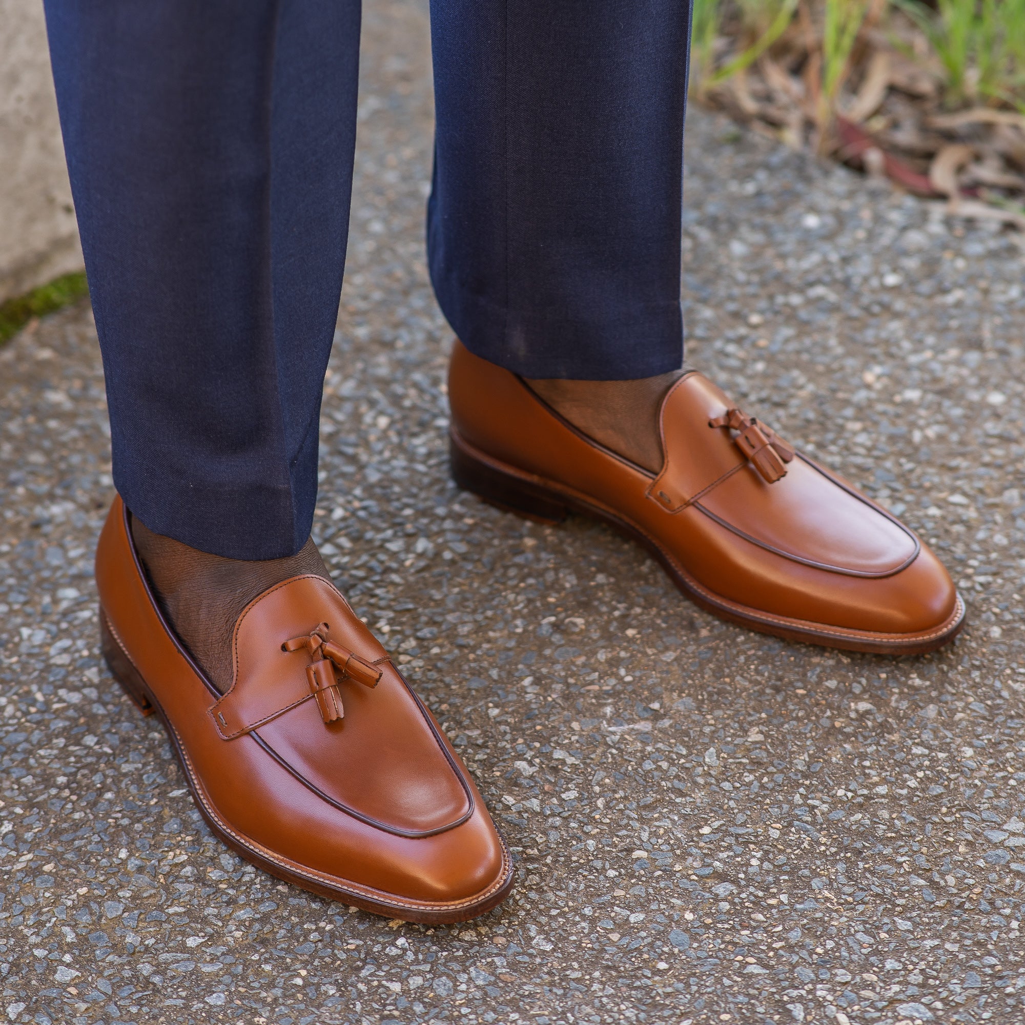 Tan loafers with tassels paired with slim fit suit and without sock for trendy look