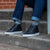 White and black high top sneakers styled with blue slim denim and 100% striped socks.